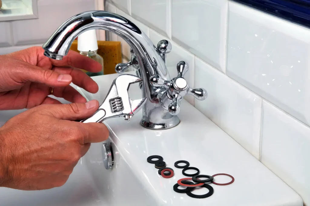 Plumber performing maintenance on a bathroom faucet in Chambersburg