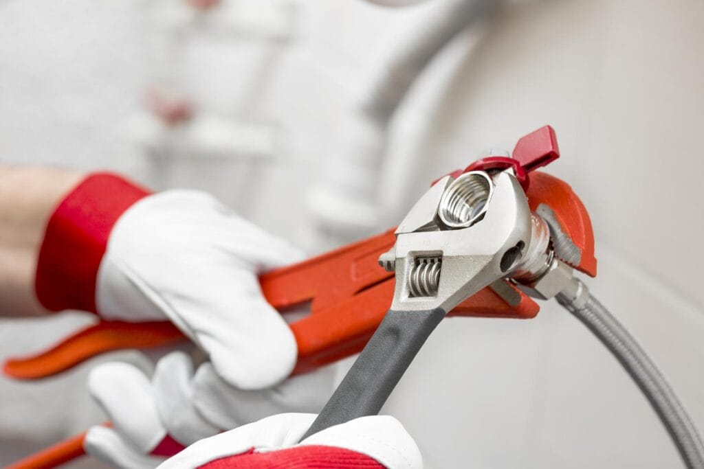 Plumber holding pipe wrenches for an emergency repair in Chambersburg