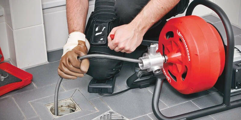 Plumber using a drain-cleaning machine in Chambersburg