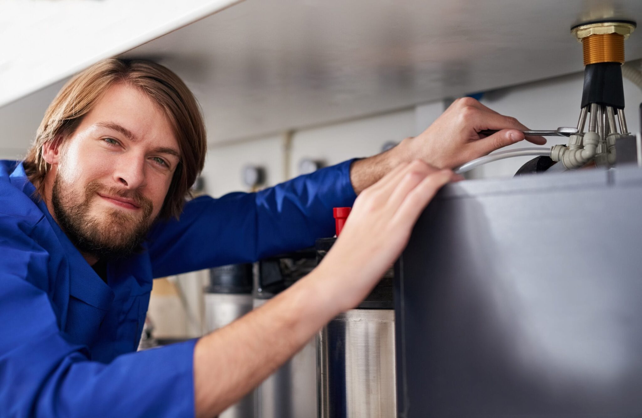 Technician servicing a residential water heater tank in Chambersburg
