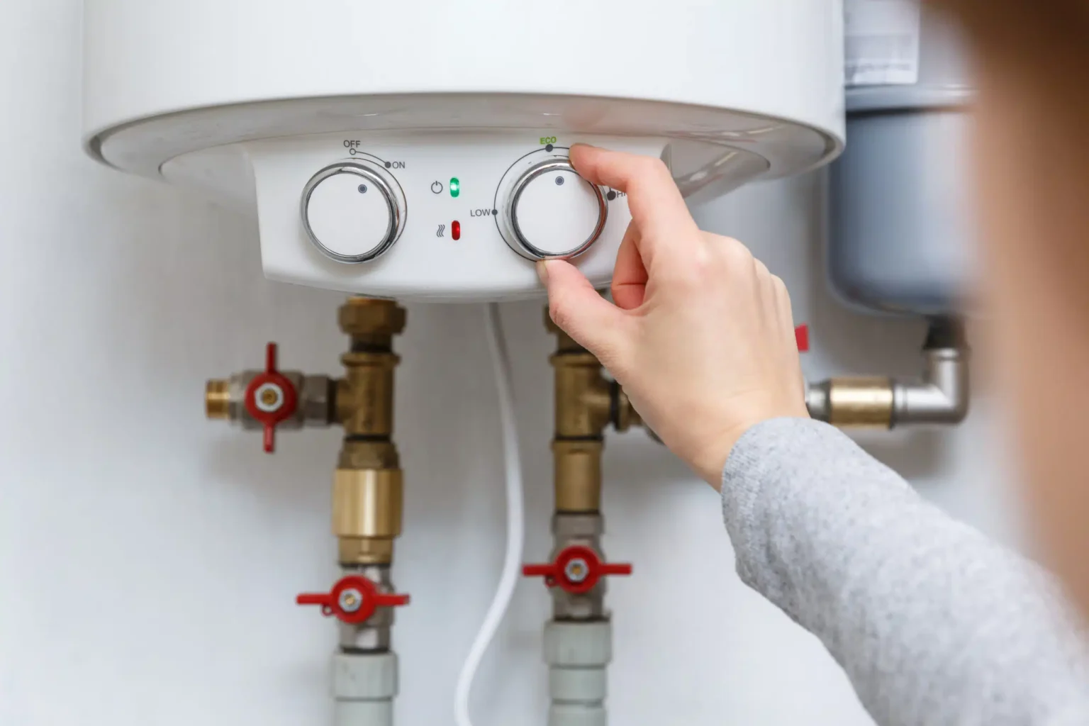 Homeowner adjusting the temperature controls on a water heater in Chambersburg